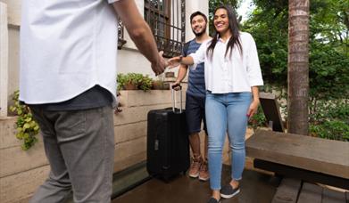 Stock image showing a couple arriving at their accommodaiton.