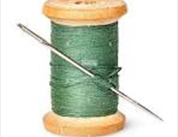 Picture of a spool of thread with needle through it