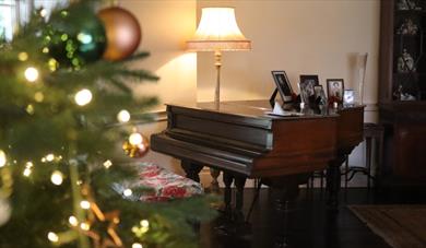 Christmas tree next to a piano