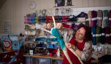 Devon Open Studios - woman in red dress working on large textile figure