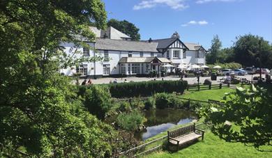 View of the hotel and front gardens on a sunny day