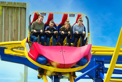 A photo of a family having fun on a Rollercoaster that twists and spins.