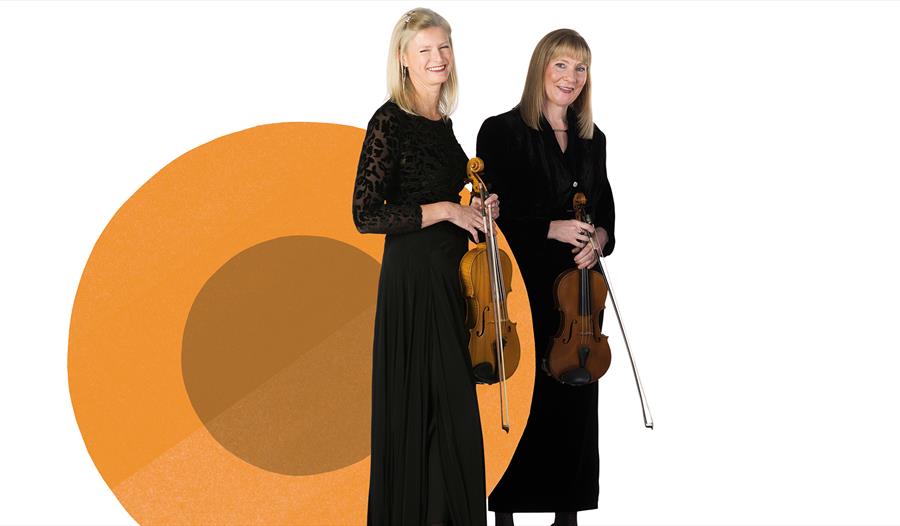 Two ladies in black dresses holding violins in front of a white background with an orange circle.