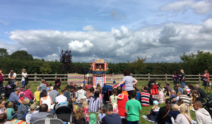 Children and families enjoy Punch & Judy show at Summer Fair