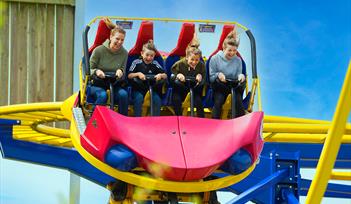 A photo of a family having fun on a Rollercoaster that twists and spins.
