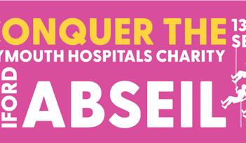 Pink banner displaying the text "Conquer the Plymouth Hospitals Charity" and "13 to 14 Sept" in bold letters.