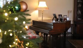 Christmas tree next to a piano