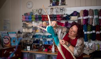 Devon Open Studios - woman in red dress working on large textile figure