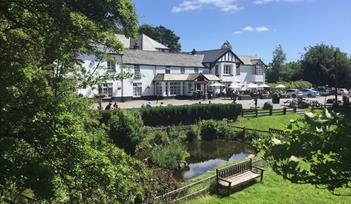 View of the hotel and front gardens on a sunny day