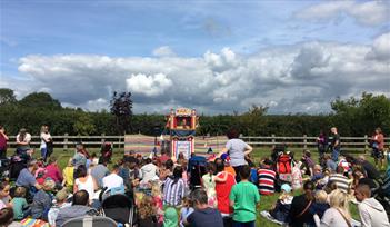 Children and families enjoy Punch & Judy show at Summer Fair