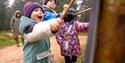 Children wave their sticks on the Stick Man activity trail