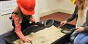 Children using metal detectors in a dig tray