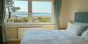 This bedroom can be configured as a superking or twin beds. It enjoys stunning sea views and a sink with mirror (handy for toothbrushing), a wardrobe,
