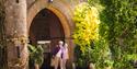 Two people walking out of the old and historic Knighthayes estate into the garden