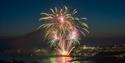 Fireworks launching from the pier at night