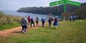 A group of people walking along the South West Coast Path between Paignton and Brixham.