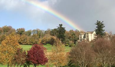 Rainbow over autumn trees on grounds of Bovey Castle