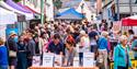 Crowds of people head up Fore Street in Bovey Tracey enjoying the food and drinks stands at Nourish Festival