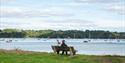 Couple sat looking at River Dart in Dittisham