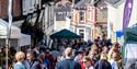 A crowded street at Nourish Festival. View down Fore Street with countryside in the distance.