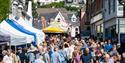Looking up Fore Street, crowds of people enjoying Nourish Festival in Bovey Tracey, Devon.