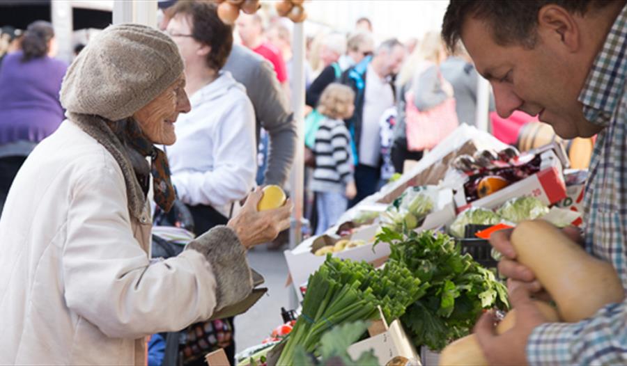 A person enjoys choosing from fresh vegetables at a market stall A person enjoys choosing from fresh vegetables at a market stall
