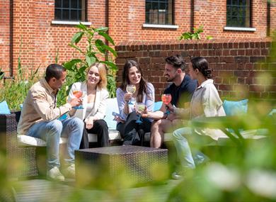Group of friends gathered at Bombay Sapphire Distillery for Aperitivo Evenings - sitting outside by the River Test