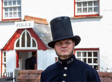 man dressed as victorian police man outside police station