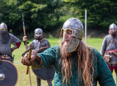 man in viking outfit holding sword