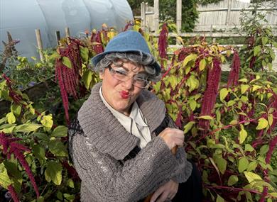 Effel Fartwaffer crouched down between some purple coloured plants