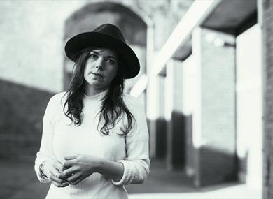 Image: Black and white image of Jessie Reid standing outside