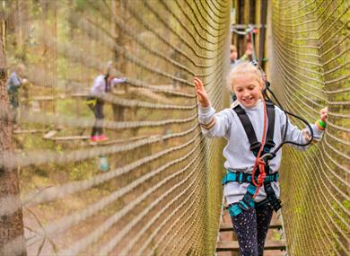 Girl having a go at the tree tops challenge at Go Ape in Swinley Forest, Bracknell
