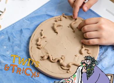 A child's hands playing with clay at Roald Dahl Museum and Story Centre, Buckinghamshire