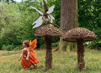 A child dressed as a fairy plays amongst the willow fungi