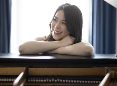 Image: Sherri Lun standing over piano