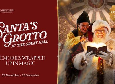 Santa reading from a book and his elf behind him