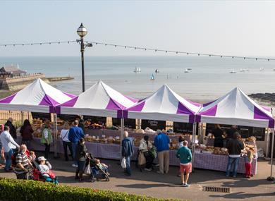 Group of purple and white covered stalls on Broadstairs seafront selling food and drink