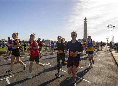 People taking part in the Great South Run, going past the War Memorial on Southsea Seafront