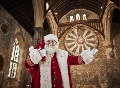 Father Christmas with The Great Hall and Round Table in the background.