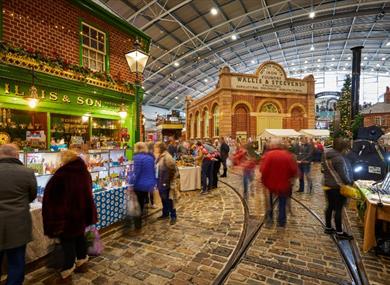 People walking around a museum at a Christmas market
