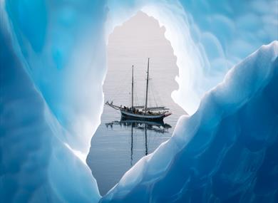 A yacht on the water through a hole in the ice