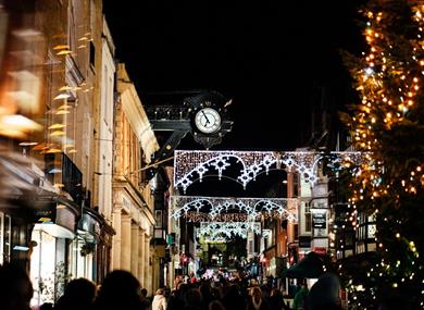 Winchester high street at night with Christmas lights and a Christmas tree.