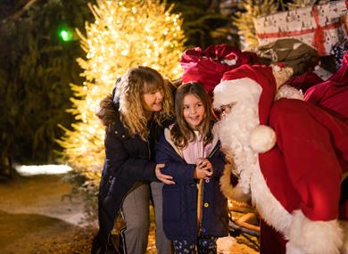 Little girl smiling with her grandmother and santa