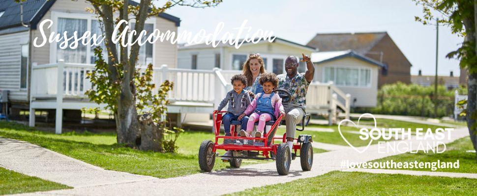 Family having fun on bike at Camber Sands Holiday Park in East Sussex