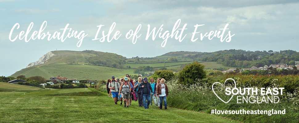 Group walking with the stunning Isle of Wight coastline in distance