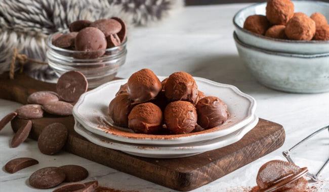 Chocolate truffles on a plate, surrounded by chocolate buttons