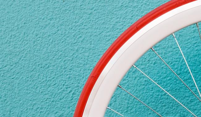 Bicycle wheel against a bright wall