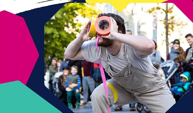 A social card promoting Basingstoke Festival. The main image is a person dressed in cream dungarees holding colourful duct tape to create the look of