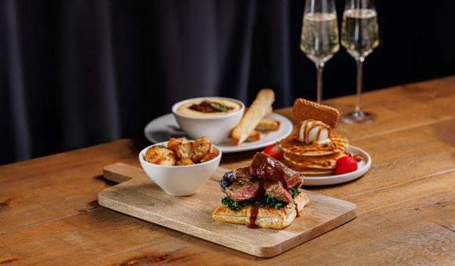 Image shows an assortment of 3 courses available from Beefeater's Set Valentine's Menu, including a starter, main and dessert. 2 glasses of Prosecco a