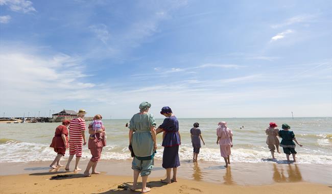 Dickensian dressed people bathing party on beach